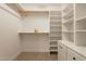 A walk-in closet with multiple shelves, hanging racks, and bright white walls at 12946 W Maplewood Dr, Sun City West, AZ 85375