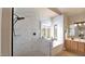 Bright bathroom with a glass shower, soaking tub, shutters, and elegant marble-look tile at 1302 E Voltaire Ave, Phoenix, AZ 85022