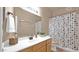 Well-lit bathroom featuring a neutral color scheme, large mirror, and shower with a polka dot curtain at 1302 E Voltaire Ave, Phoenix, AZ 85022