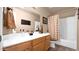 Bathroom featuring a double sink vanity and shower-tub combo with neutral tile at 1302 E Voltaire Ave, Phoenix, AZ 85022
