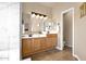 Double vanity bathroom with wood cabinets, tiled floors, and marble look tile at 1302 E Voltaire Ave, Phoenix, AZ 85022