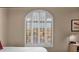 Bedroom with a large arched window and shutter and soft neutral walls at 1302 E Voltaire Ave, Phoenix, AZ 85022