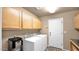 Spacious laundry room with washer, dryer, cabinets, and access to the exterior at 1302 E Voltaire Ave, Phoenix, AZ 85022