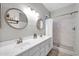 Modern bathroom showcasing double sinks, updated lighting, and tiled walk-in shower at 13534 W Young St, Surprise, AZ 85374