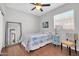 Cozy bedroom with hardwood floors, ceiling fan, and large window at 13534 W Young St, Surprise, AZ 85374
