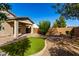 Well-kept backyard with a covered patio, artificial grass, and desert landscaping for outdoor enjoyment at 141 W Jamaica Pl, Casa Grande, AZ 85122