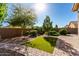 Backyard featuring green artificial turf, mature landscaping, and a brick-paved patio at 141 W Jamaica Pl, Casa Grande, AZ 85122