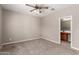 Carpeted bedroom with ceiling fan and en-suite bathroom with neutral colors at 141 W Jamaica Pl, Casa Grande, AZ 85122