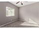 This bedroom has carpet flooring, a window with blinds, neutral-colored walls, and a ceiling fan at 141 W Jamaica Pl, Casa Grande, AZ 85122