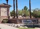 Community entrance featuring stone accents, a water feature, and palm trees at 141 W Jamaica Pl, Casa Grande, AZ 85122