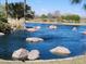 Scenic pond view featuring rock formations and surrounding greenery, creating a tranquil setting at 141 W Jamaica Pl, Casa Grande, AZ 85122