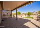 Charming covered patio with brick pavers and manicured landscaping perfect for outdoor entertaining at 16016 W Indigo Ln, Surprise, AZ 85374