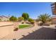 Paver patio with built-in seating, lush landscaping, and privacy fence create a relaxing outdoor space at 16016 W Indigo Ln, Surprise, AZ 85374