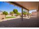 Covered patio with a view of a beautifully landscaped backyard with artificial grass at 16016 W Indigo Ln, Surprise, AZ 85374