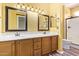 Well-lit bathroom featuring a double sink vanity with wood cabinets and a glass-enclosed shower at 16016 W Indigo Ln, Surprise, AZ 85374