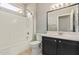 Bathroom with a shower-tub combo and black vanity with marble countertop at 16016 W Indigo Ln, Surprise, AZ 85374