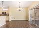 Bright dining room features stylish chandelier, wood floors, and sliding glass door access to outdoor patio at 16016 W Indigo Ln, Surprise, AZ 85374
