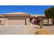 Tan home showing the garage, tiled roof, desert landscaping, and rose bush by the front door at 16016 W Indigo Ln, Surprise, AZ 85374