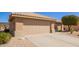Garage with a wide driveway and desert landscaping featuring cacti and gravel at 16016 W Indigo Ln, Surprise, AZ 85374