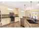 Well-lit kitchen boasts stainless steel appliances, granite counters, and ample cabinet space at 16016 W Indigo Ln, Surprise, AZ 85374