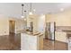 Open kitchen concept with bar seating, stainless steel appliances, and wood-style flooring at 16016 W Indigo Ln, Surprise, AZ 85374
