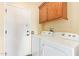 Functional laundry room with overhead cabinet storage and a side-by-side washer and dryer at 16016 W Indigo Ln, Surprise, AZ 85374