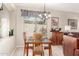 Cozy dining room featuring a glass top table with seating, chandelier and backyard views at 16601 S 16Th Dr, Phoenix, AZ 85045