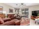 Well-lit living room with a ceiling fan, comfortable seating, and access to outdoor living at 16601 S 16Th Dr, Phoenix, AZ 85045
