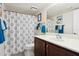 Bathroom featuring a toilet, dark vanity, mirror, and white shower curtain with blue accents at 1720 E Thunderbird Rd # 2090, Phoenix, AZ 85022