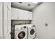 This laundry room has white cabinets and a Samsung washer and dryer at 19035 N 83Rd Ln, Peoria, AZ 85382
