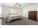 Cozy bedroom featuring neutral tones, a ceiling fan, carpet, and a well-lit window at 2277 S Apache Dr # 7, Apache Junction, AZ 85120