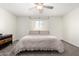 Bright bedroom featuring neutral tones, a ceiling fan, carpet, and a well-lit window at 2277 S Apache Dr # 7, Apache Junction, AZ 85120