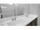 Bathroom with double sinks, a large mirror, and dark cabinets at 2296 S 235Th Dr, Buckeye, AZ 85326