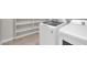 Laundry room with appliances, tile floor, and open shelves at 2296 S 235Th Dr, Buckeye, AZ 85326
