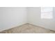 Clean, minimalist bedroom featuring soft carpeting and a bright window at 23146 E Nightingale Rd, Queen Creek, AZ 85142