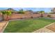The house features a well-maintained lawn, a brick fence and palm trees, enhancing the backyard appeal at 2521 W Mark Ln, Phoenix, AZ 85085