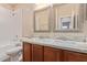 Bright bathroom features double sinks, granite countertop, framed mirrors, and tile backsplash at 2521 W Mark Ln, Phoenix, AZ 85085