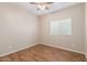 Neutral bedroom features wood floors, a ceiling fan, and a window with a view of the neighborhood at 2521 W Mark Ln, Phoenix, AZ 85085