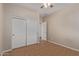 Neutral bedroom features wood floors, a ceiling fan, closet and a view of the hallway at 2521 W Mark Ln, Phoenix, AZ 85085