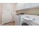 Convenient laundry room with white cabinetry, a utility sink, a washer, and dryer at 2521 W Mark Ln, Phoenix, AZ 85085