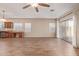 Bright living room with wood-look tile floors, a ceiling fan, and a sliding glass door leading to the outdoors at 2521 W Mark Ln, Phoenix, AZ 85085