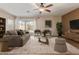 Bright living room with a ceiling fan, neutral colors, and sliding glass doors to the backyard at 2521 W Mark Ln, Phoenix, AZ 85085