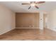 Neutral living room with wood-look tile floors, a ceiling fan, and a view of the hallway and bedroom doors at 2521 W Mark Ln, Phoenix, AZ 85085