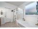 Bright bathroom featuring a soaking tub with glass shower, white cabinets, and tiled flooring at 25330 N 134Th Dr, Peoria, AZ 85383