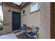 Covered patio with dark metal seating, offering a cozy outdoor space, and textured walls at 25330 N 134Th Dr, Peoria, AZ 85383