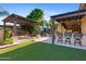 Expansive backyard with outdoor kitchen, covered lounge, and a pristine pool area with stone waterfall features at 2799 E Jade Pl, Chandler, AZ 85286