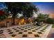 This backyard features inlaid grass details in the patio, a fireplace, and recessed lighting at 2799 E Jade Pl, Chandler, AZ 85286