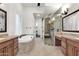 A bright bathroom featuring a soaking tub, double vanity, and a glass-enclosed shower at 2799 E Jade Pl, Chandler, AZ 85286