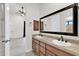 Bathroom featuring double sinks, granite counters, wood cabinets, and framed mirror at 2799 E Jade Pl, Chandler, AZ 85286