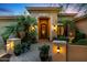 Inviting front entrance with an arched doorway, manicured landscaping, and elegant lighting at 2799 E Jade Pl, Chandler, AZ 85286